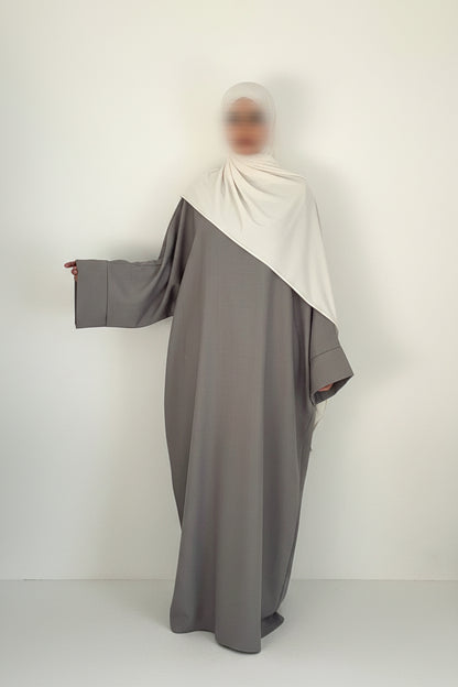 Abaya Saoudienne grise aux manches évasées et large avec un foulard blanc